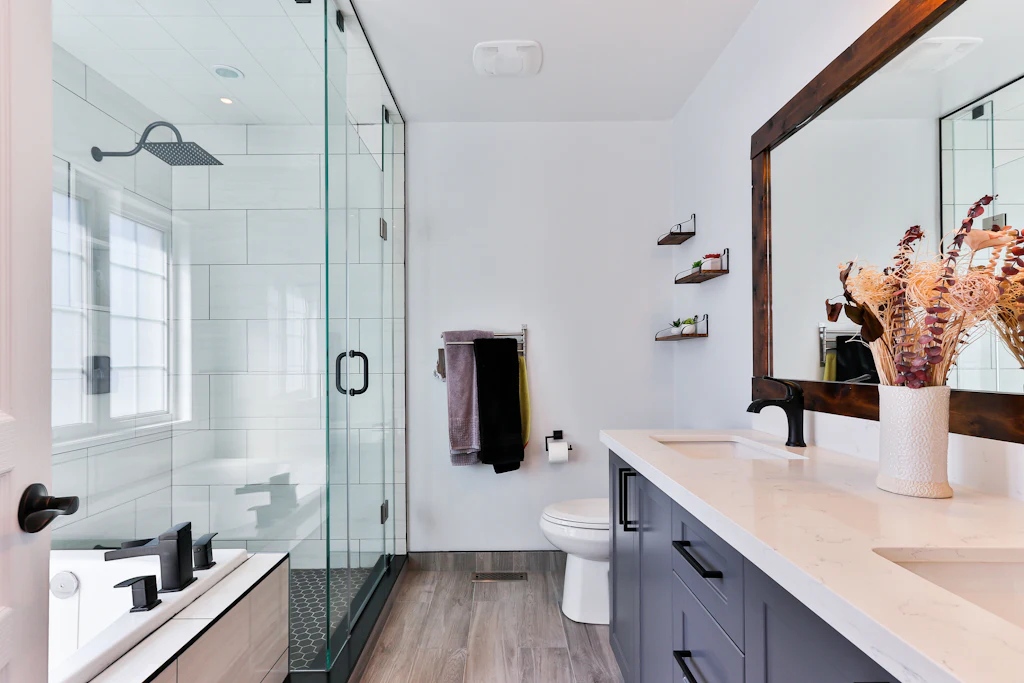 Baño moderno con ducha de vidrio, vanitory y grifería negra